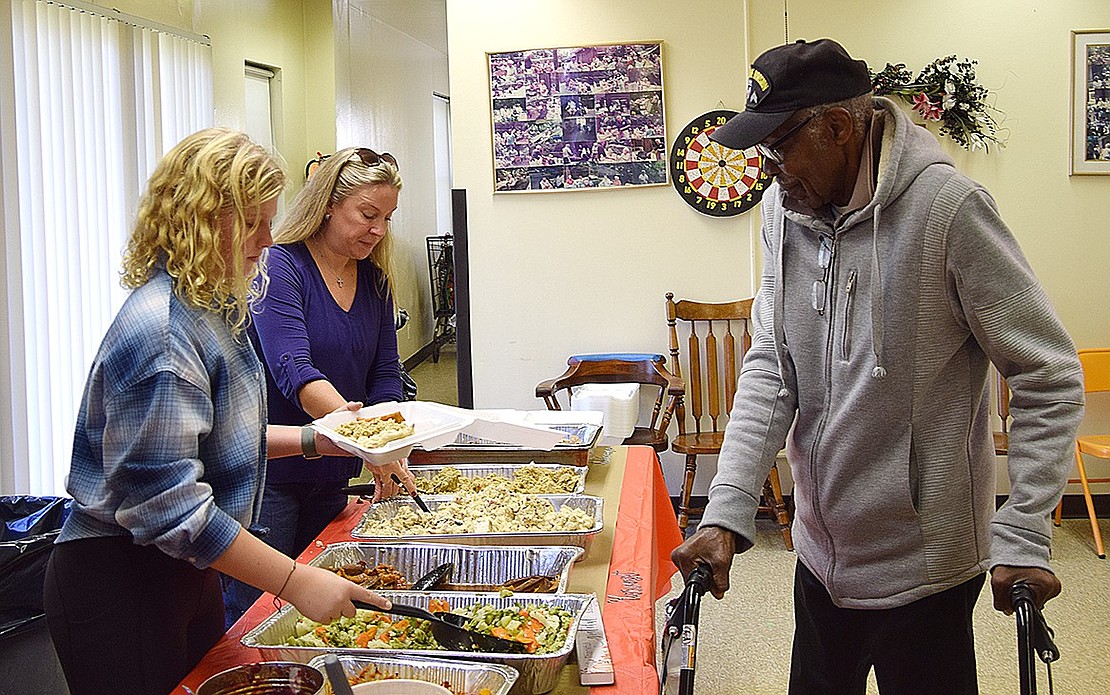 John Pompey, one of the residents of the senior housing complex on Drew Street, gets his fill of food at the 37th annual Corporate Outreach Thanksgiving dinner on Saturday, Nov. 18.