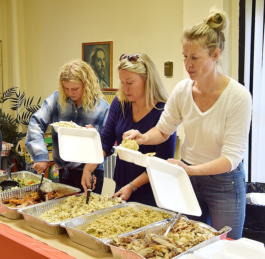 The volunteers from Corporate Outreach prepare to-go boxes to deliver to tenants who can’t physically attend the event. Riley Anderson (left) is joined by her mother, Shannon Anderson, both of Purchase, and Lauren Spelman, who lives in Greenwich, Conn. It’s Spelman’s second year serving food at the event, while the Andersons started volunteering with Corporate Outreach seven years ago, when Riley was 5 years old.