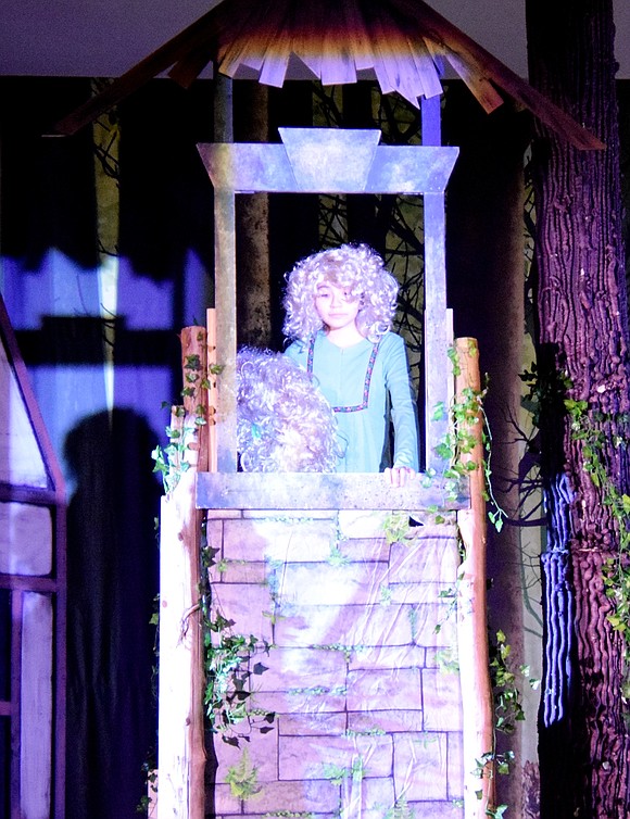 Rapunzel, who is played by eighth-grader Cielo Veintimilla, prepares to drop her hair down a tall tower for the witch to climb up.