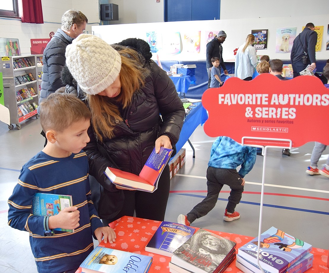 First-grader Phinn Benoit looks through the book “Toy Story” by Kelly Yang with his mom, Lisa.