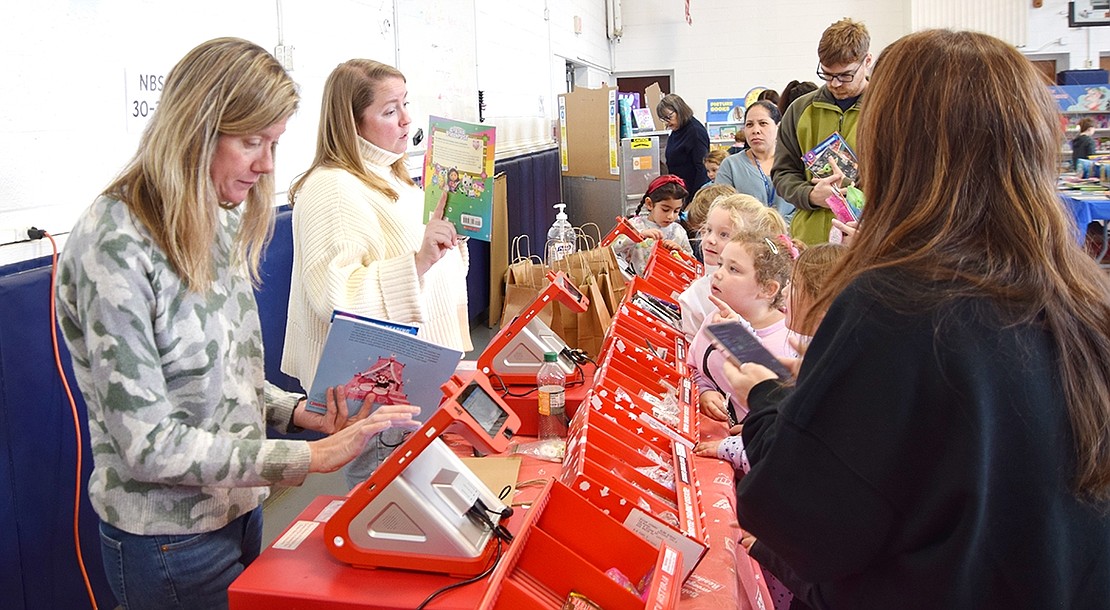 Blind Brook PTA Co-president Correy Stephenson (left) and member Alicia Scala work at the registers, helping students and adults alike with their purchases.