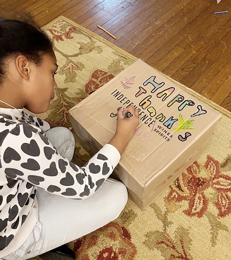 Girl Scout Savannah Jones decorates a box in which the makings of a Thanksgiving dinner will be inserted for distribution to a needy Port Chester family.