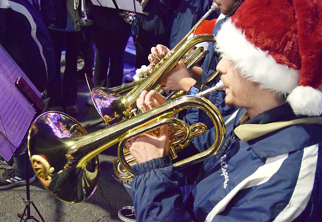 Donning a Santa hat, Port Chester High School senior Thomas d’Esperies’s festive look shines back at him from his mellophone’s horn.