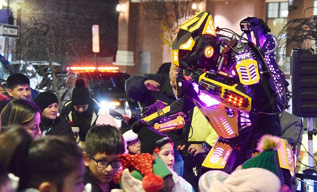 An event for all sentients, the Christmas tree lighting celebration saw a large robot in the crowd, who was happy to give out high-fives and pose for pictures with children present.