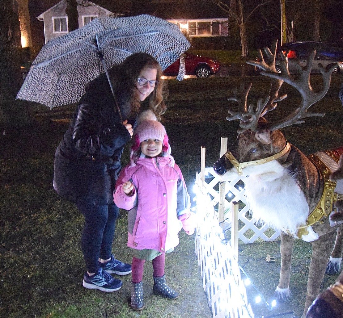 Harrison resident Laurie Worby poses with her niece, 4-year-old Louisa Colacino of Rye Brook, next to the mechanical reindeer that were present at the park.