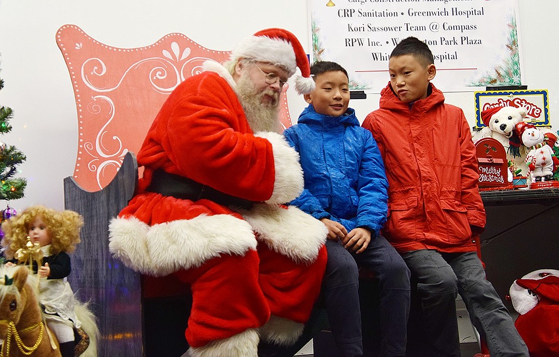 Santa Claus, who masquerades as Chris Paliulis of Chris and Pete Amusements during the rest of the year, asks brothers Andrew (left) and Noah Chen what they would like for Christmas this year. The boys said they weren’t sure, and Santa jollily told them that was a fair response, so long as they stayed nice for the rest of the year. Andrew is a Ridge Street School fifth-grader and Noah is a Blind Brook Middle School sixth-grader.