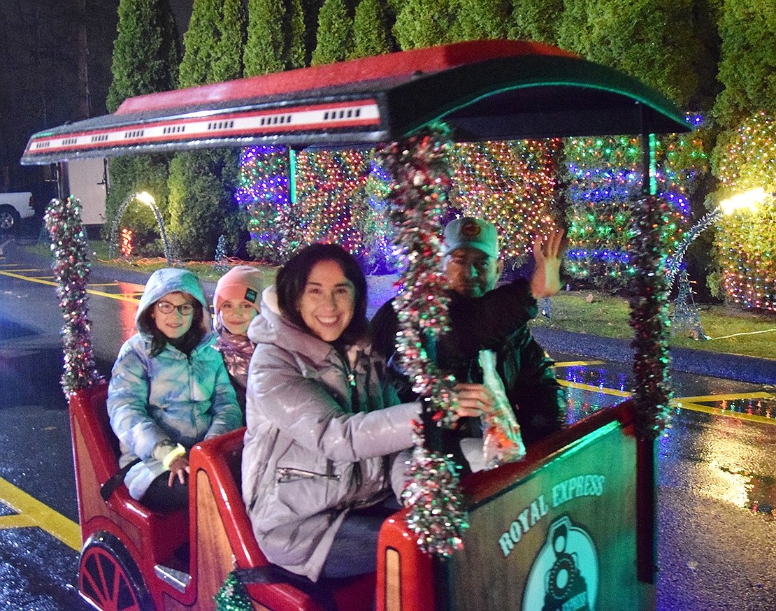 Third graders at Ridge Street Elementary School Preslie Sofia (left) and Zara Bass ride the Royal Express train back from their visit to Santa Claus. Rye Brook parents Jessica Andruk and Joel Bass sit in the car ahead of them, chaperoning a larger group.