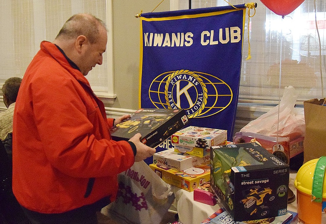 Port Chester resident Raymond Sculky, a member of the Port Chester/Rye Brook Kiwanis Club for 38 years, drops off a toy that will be given to a child during the Don Bosco Center’s “Breakfast with Santa” event on Dec. 16. The service club celebrated its 60-year anniversary with a dinner on Tuesday, Dec. 5.