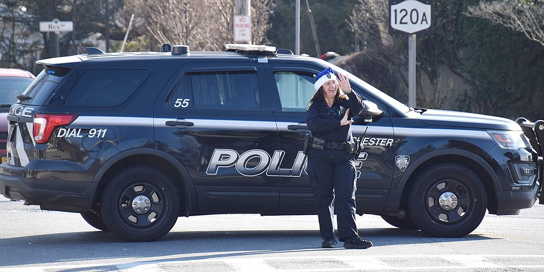 Port Chester police officers working the parade, such as Melissa Rosario, show their holiday spirit by wearing blue Santa hats.