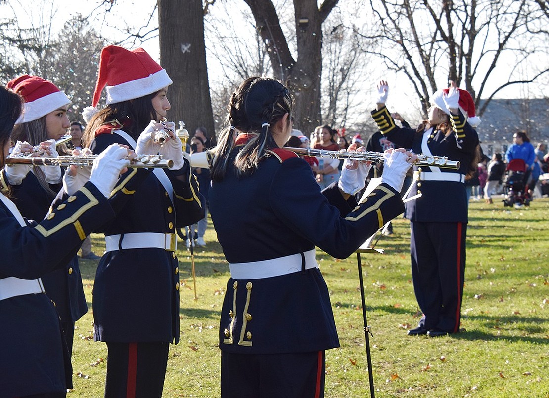 Pride of Port Chester Drum Major Sofia Coyt, a sophomore, conducts the musicians through holiday tunes as they perform for the hundreds of spectators visiting Lyon Park.