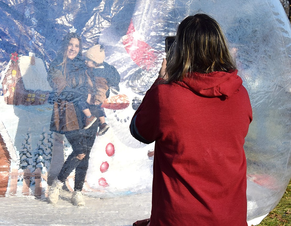 Regina Royo captures the moment as her daughter Patricia Reyes and 1-year-old grandson Ismael Reyes step into a winter wonderland snow globe to pose for a photo. The three generations of family all live in Port Chester.