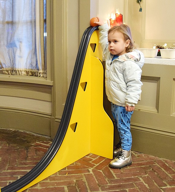 Two-year-old Olive DiSalvo, from Port Chester, prepares to roll a ball down the rollercoaster exhibit brought to the event by the Westchester Children's Museum.