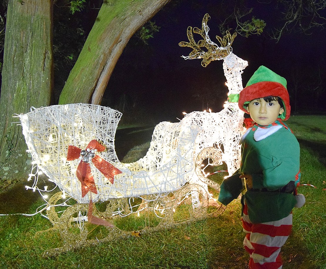 Ethan Mizhquero, a 2-year-old from Port Chester, explores one of the lit displays set up around the park. His mother Jessica dressed him up as an elf for the night.