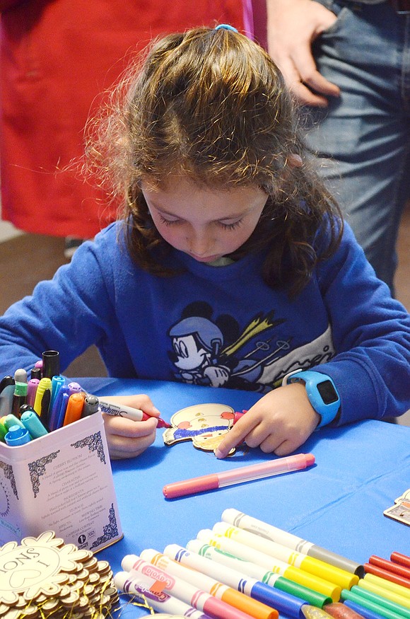 Four-year-old Maya Saffer of Browndale Place carefully colors a snowman ornament at one of the craft tables.