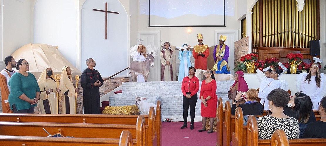 The entire cast, including those unseen during the performance, make an appearance at the end of the Christmas play. It was directed by Cheryle Washington (wearing red dress).