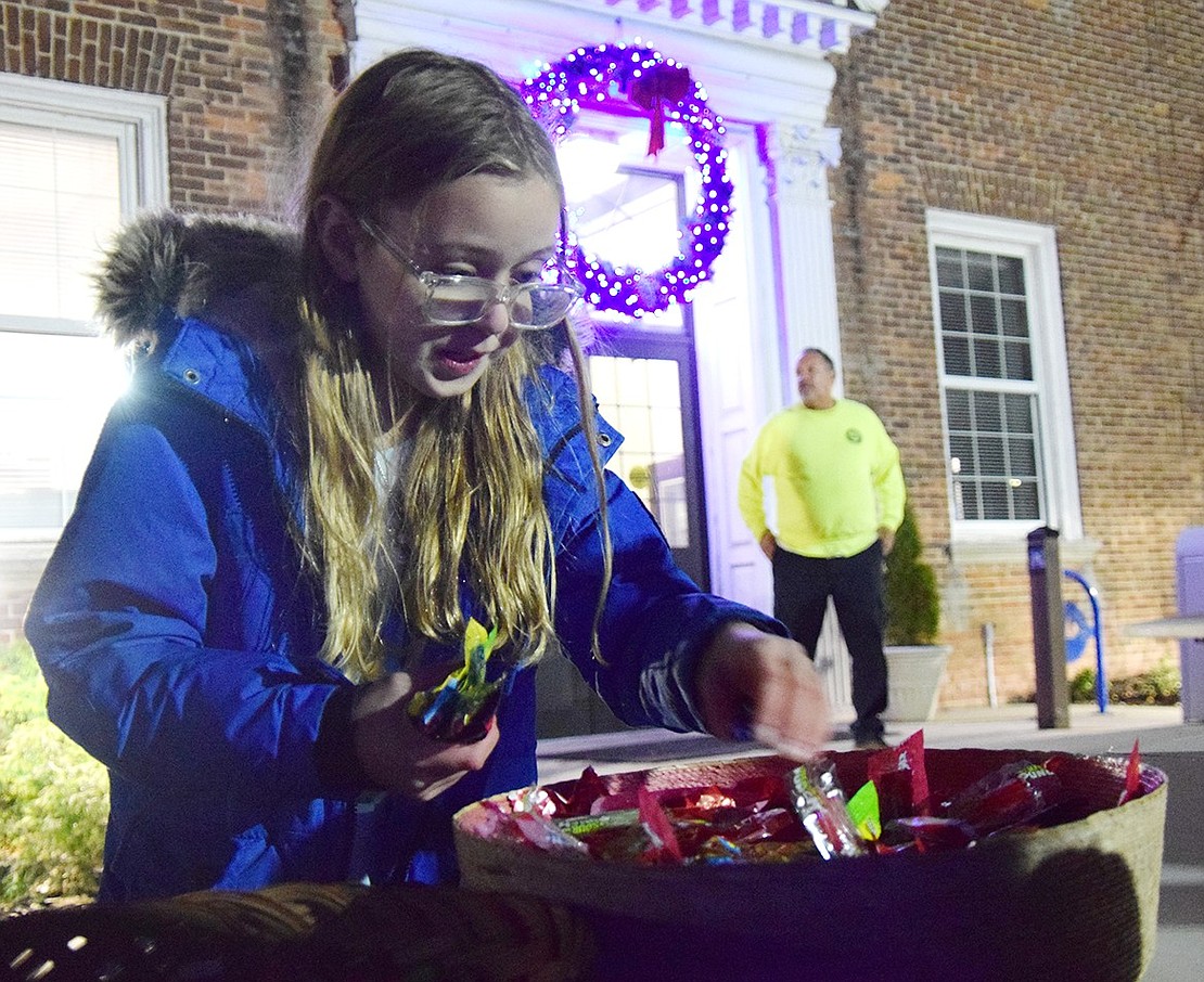 King Street School fifth-grader Arianna Butkiewicz helps herself to some of the sweets available after the gelt drop.