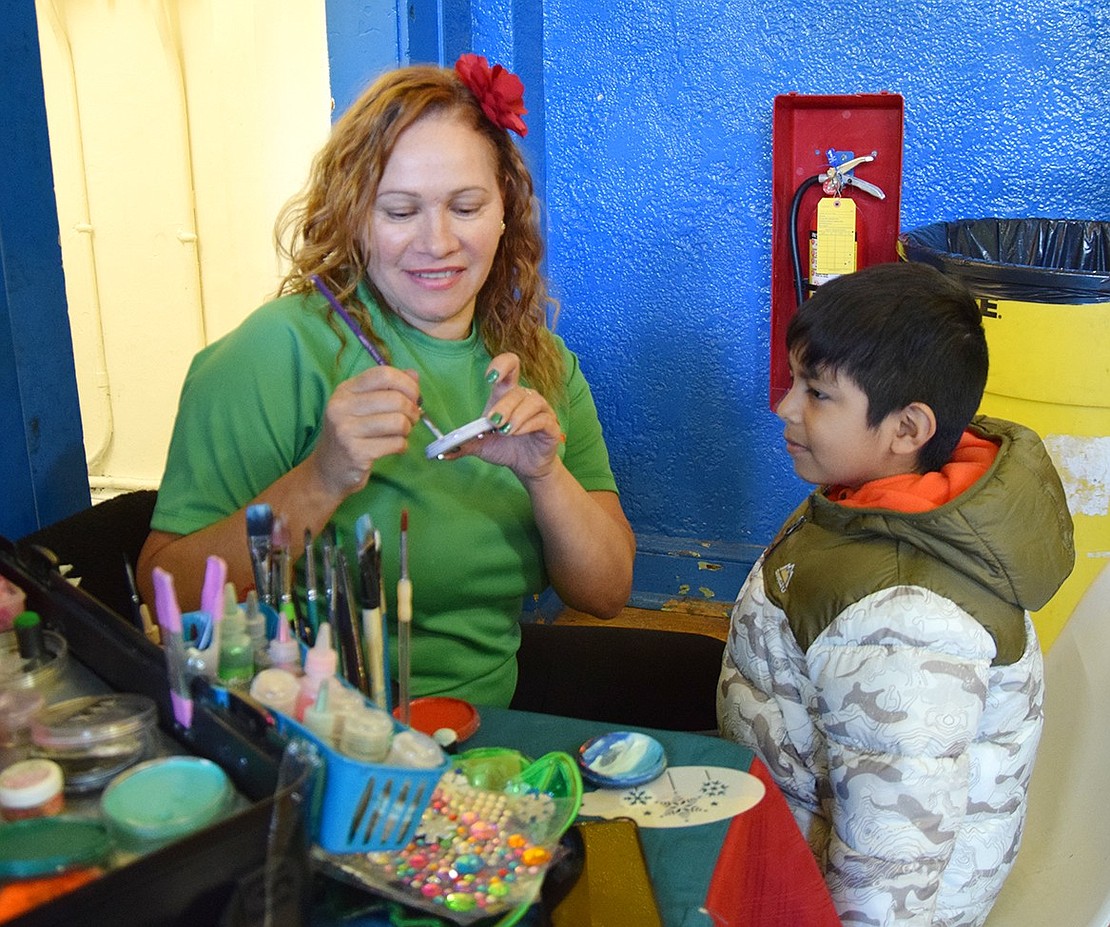 Sandra Pena of the New York City-based Judy Kids Entertainment prepares to paint the face of Port Chester resident Eneas Rojas. The 6-year-old requested a Spider-Man pattern.