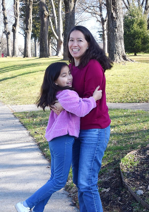 Unable to contain her joy after seeing Santa ride down Putnam Avenue, King Street School second-grader Nina Barrenechea jumps into the arms of her mother, Ana.