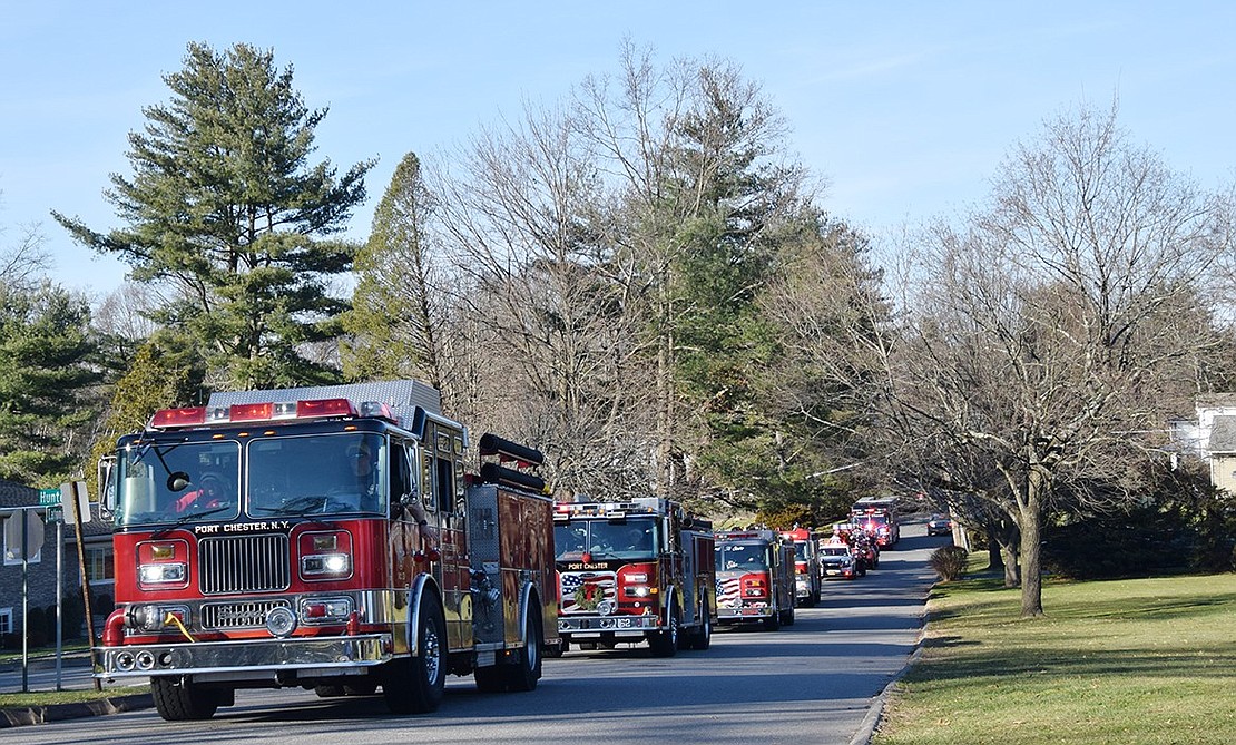 The convoy of firetrucks makes its way down Latonia Road, passing Pine Ridge Park.