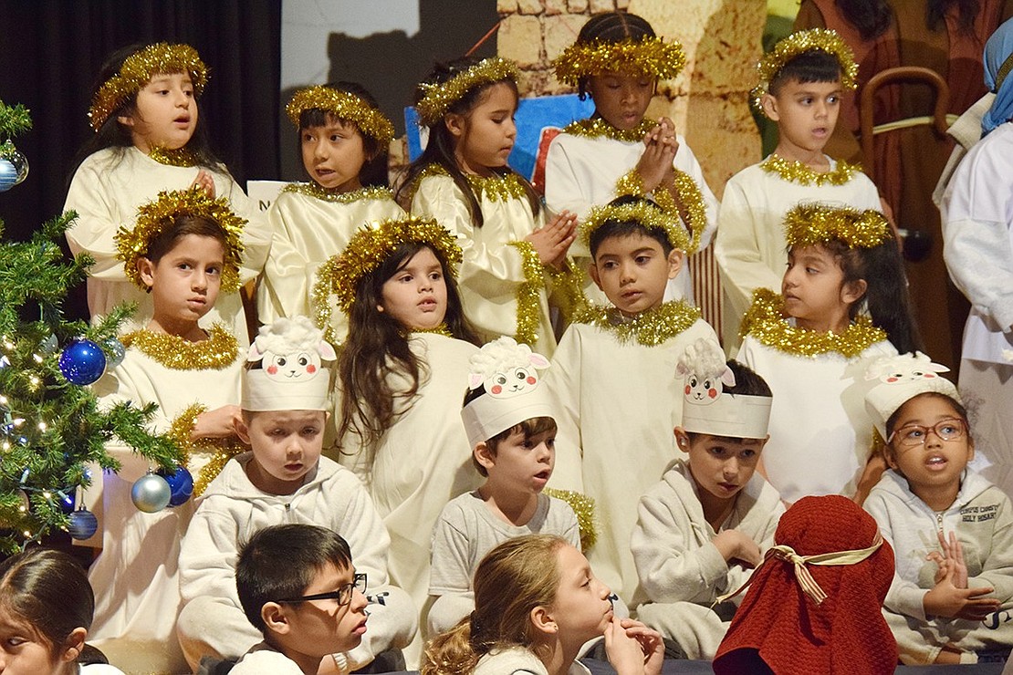 With first-graders playing the angels and kindergarteners portraying sheep, ensemble students hop on stage to sing “We Three Kings” during the royal arrival.