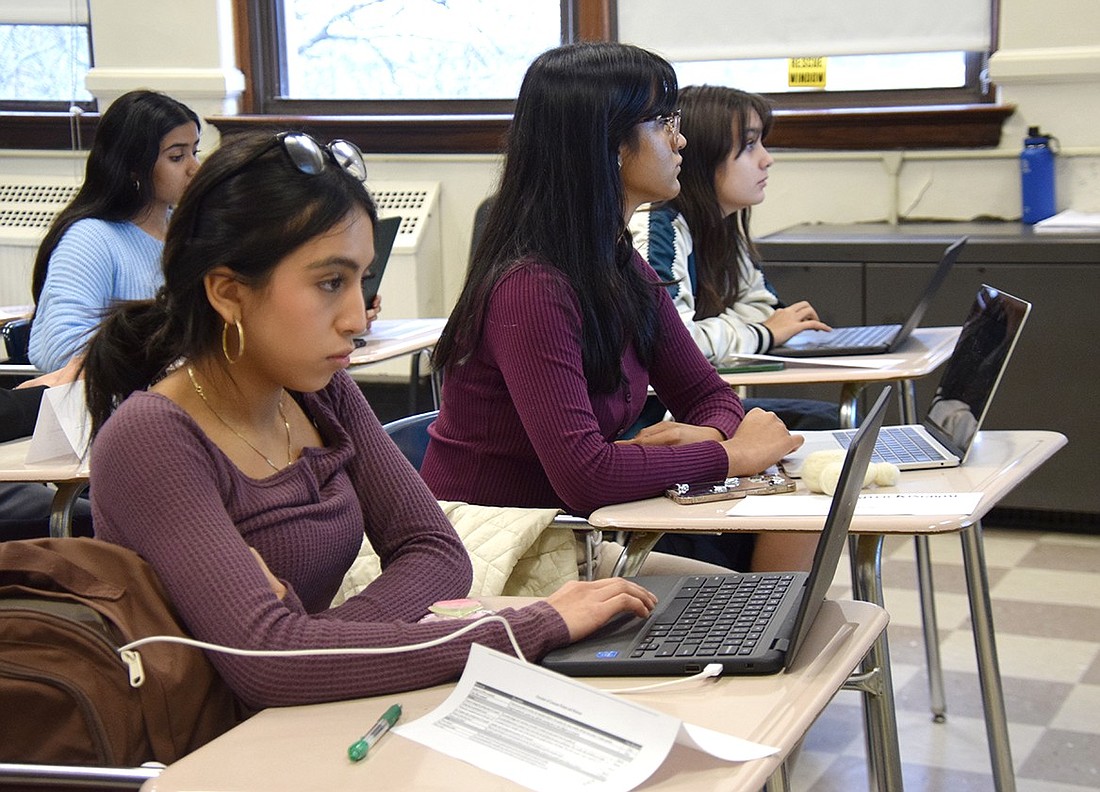 Once given their prompt, Port Chester High School students junior Katherine Balbin (left), junior Kanishka Patel and senior Ava Osorio whip out their laptops to begin researching the South Sudan Refugee Crisis on Dec. 6. As members of the school’s newly reinstated Model UN club, they’re practicing a problem to keep them thinking on their feet while considering global issues.