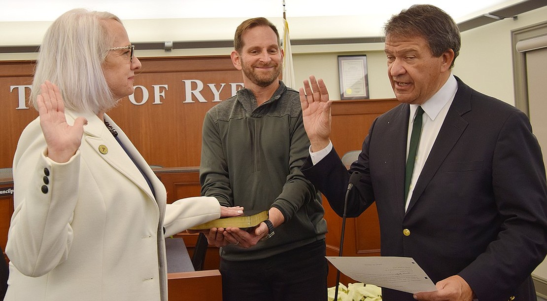 Pam Jaffee takes her oath of office as her husband, Blind Brook Board of Education member Scott Jaffee, holds the Bible for her, marking the start of her second four-year term.