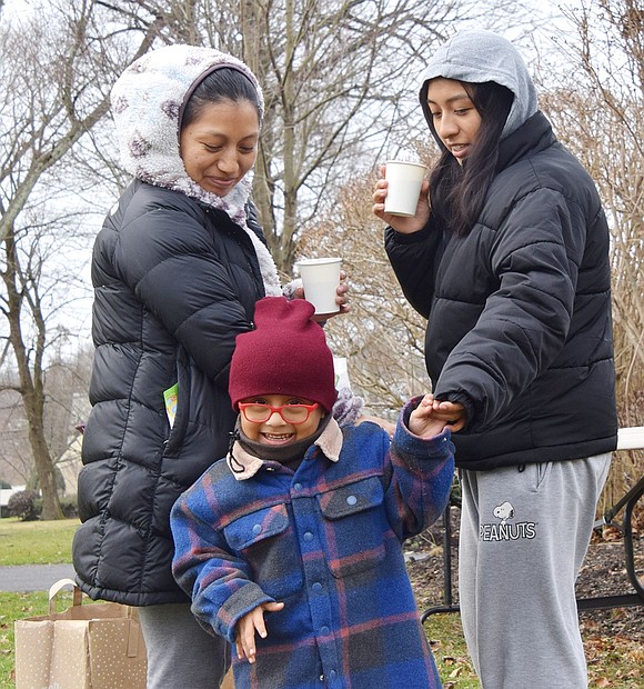 After dropping off their tree, Alicia Barreto (left) warms up by drinking hot chocolate with her children Owen, 3, and Natalie, a Port Chester High School senior. The family lives on Poningo Street.