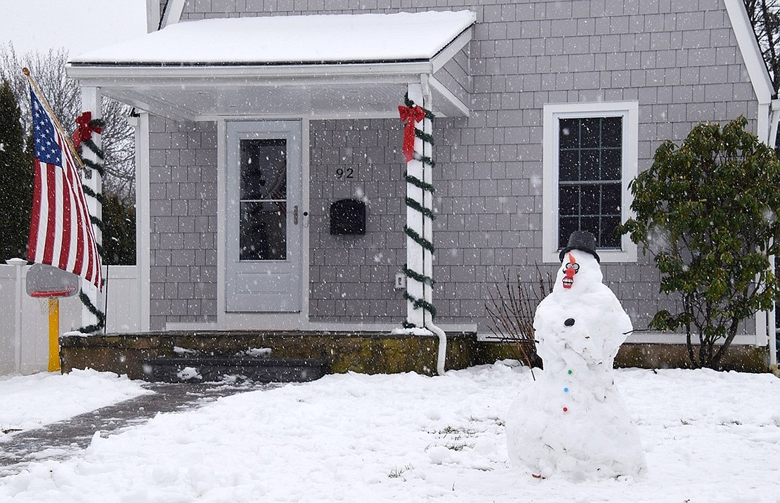 A newly crafted snowman with a scary face adds to the patriotic holiday décor at 92 Windsor Rd., corner of Argyle.