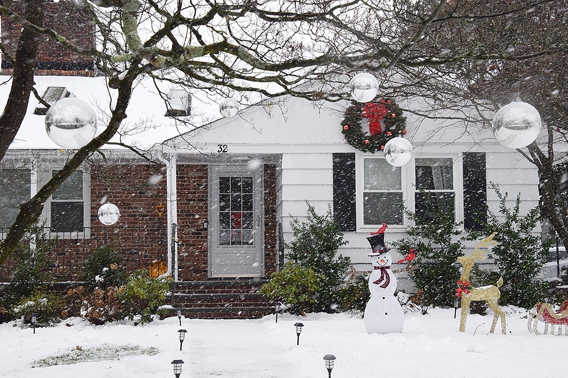 It’s a winter wonderland at 32 Ridge Blvd. Sunday afternoon, Jan. 7, as snow swirls around large silver balls hanging from the trees, a fake snowman adorned with cardinals and other Christmas decorations.