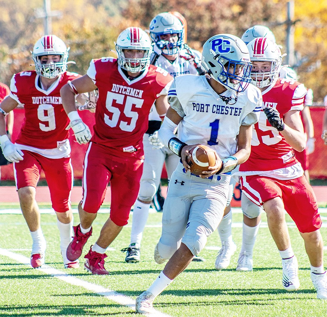 Port Chester High School quarterback Alexis Morel runs the ball away from Tappan Zee defensemen during their game on Oct. 28 in Orangeburg. After realizing they lacked the numbers to field a team, the Blind Brook School District proposed a football merger with the Port Chester School District in late 2023, but the neighboring communities were unwilling to help each other.