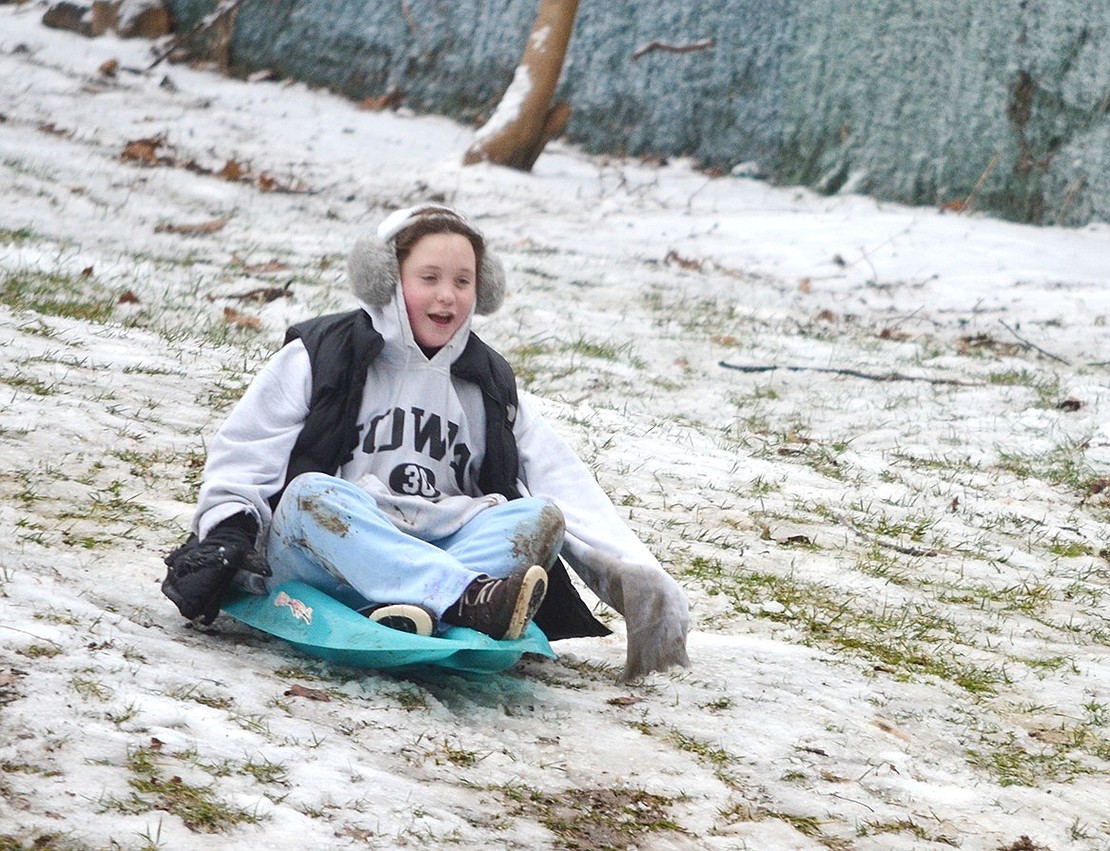 Clementine Amestoy, 11, of Carleton Lane heads down the main hill on the North Ridge Street side of Crawford Park Tuesday afternoon, Jan. 16, the first snow day of the school year, with joy, despite the icy conditions. Two to three inches of snow followed by freezing rain made for a rough sliding track.