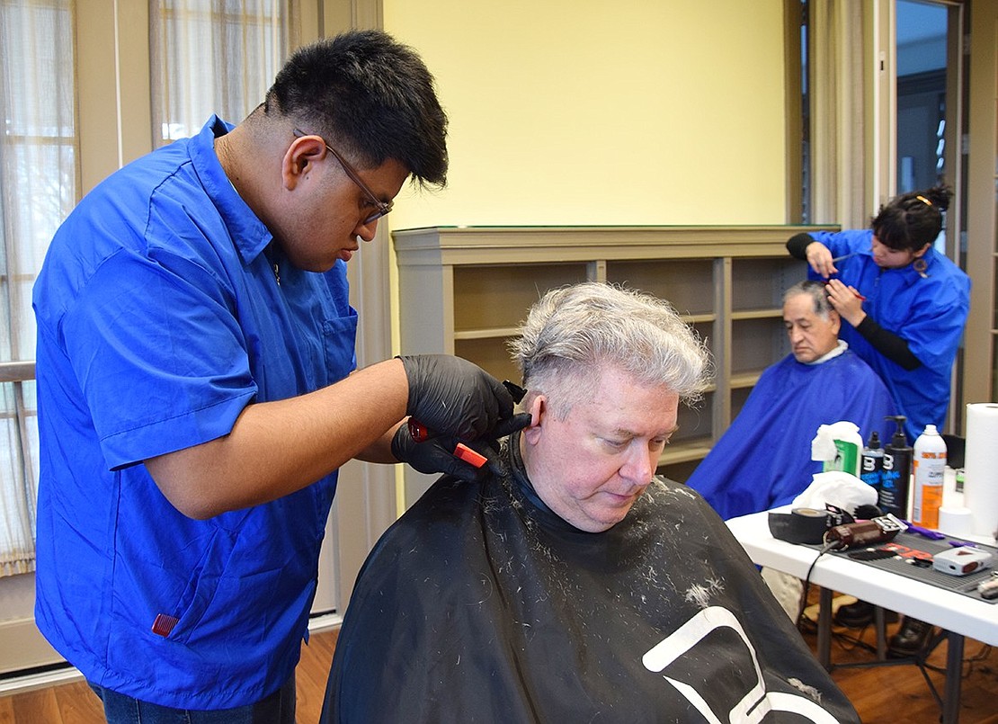 Valdomar Marroquin, who lives in Mount Vernon, folds in Tim Purk’s ear to get just the right angle for his hair clipper. Purk, a Rye Brook resident, said it’s the first time he hasn’t cut his own hair since the COVID-19 pandemic.