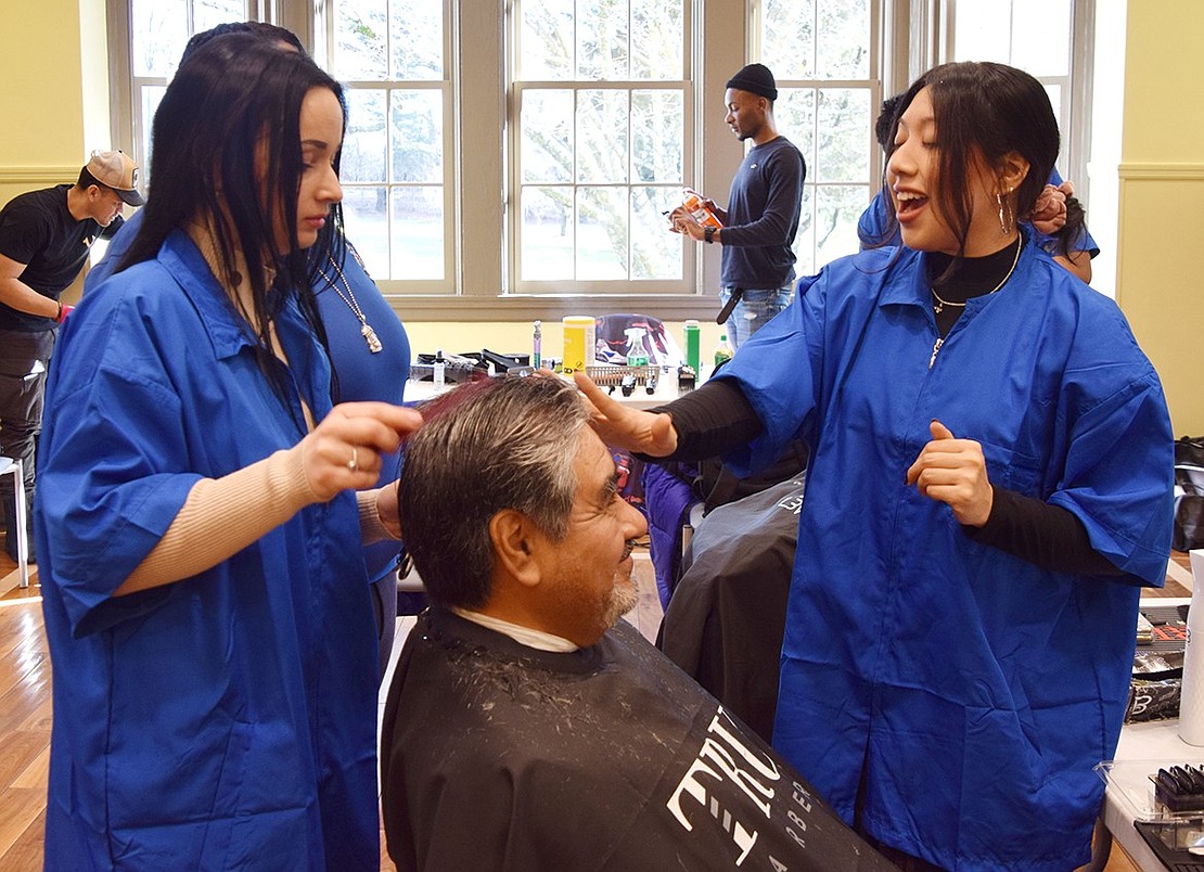 Yonkers resident Julia Ramkaran (left) cuts hair for the first time as a student with the Westchester Barber Academy. Her subject, Port Chester resident Sergio Perez, smiles as fellow student Nicole Ariza offers words of advice. To honor Martin Luther King, Jr. Day through service, the Town of Rye, in association with the Westchester Barber Academy, invited the public to the Crawford Mansion Community Center for free haircuts on Saturday, Jan. 13.