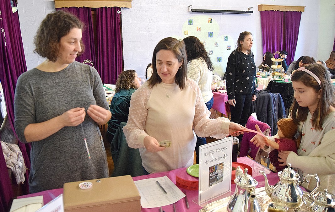 Local Girl Scout troop leaders Marissa Torento-Butkiewicz (left) and Sara Gomez sell raffle tickets to Holly Lane resident Penelope Magliacca.