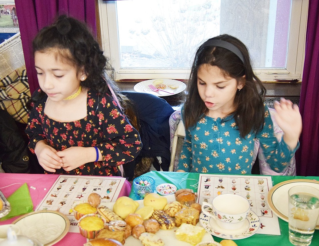 Park Avenue School second-graders Arielle Jimenez (left) and Piper Webber play bingo while fully stocked on snacks.