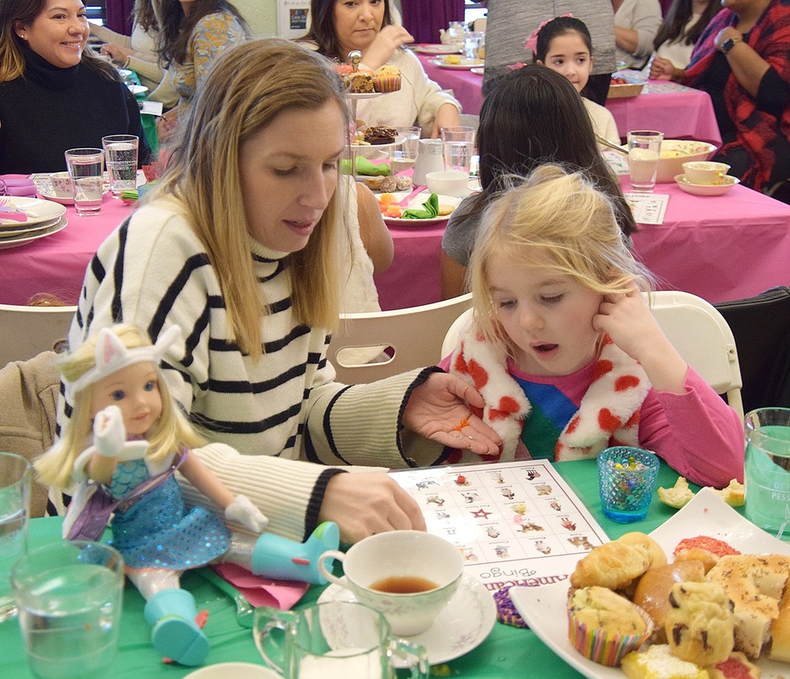 Melissa Giovinazzo, of Rye, helps her five-year-old daughter Audrey keep track of what bingo cards have been called.