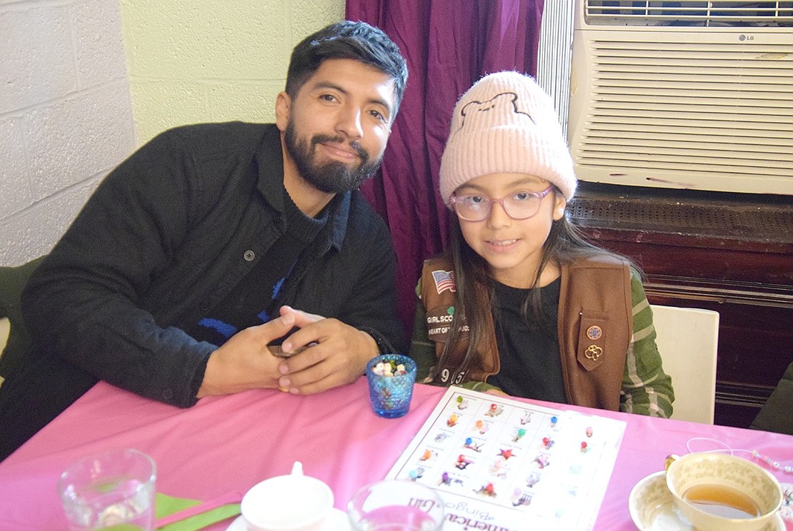 The lone dad at the tea party, Port Chester resident Juan Parra, smiles with his 8-year-old daughter Sofia during a round of bingo.