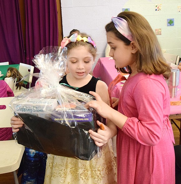 King Street School second grader Ryan Allen (left) celebrates winning a basket of toys in the raffle with her friend, 8-year-old Annabelle Damle. “I wanted this so bad,” Allen said after her name was called.