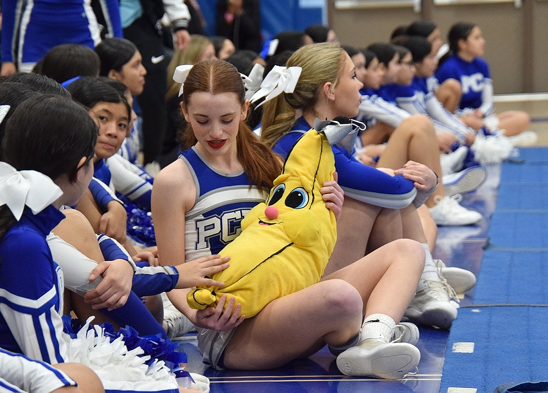 Varsity cheer team member Charlotte Burke, a sophomore supporting the other cheer teams from the sidelines, shows off a stuffed banana she brought to the exhibition.