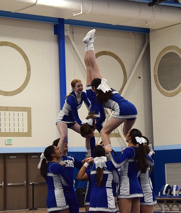 Junior Fiona Lovallo performs a daring handstand on the shoulders of her varsity cheer teammates.