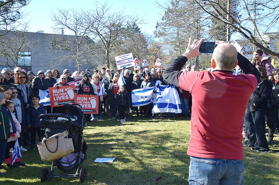 David Malchman, an Elmsford resident who organizes the Westchester Run for Their Lives rallies, takes a group video of around 200 protesters calling for the safe return of Israeli hostages captured at the beginning of the Israel-Hamas War. The group met on Sunday, Feb. 4, outside the Jewish Community Center Mid-Westchester in Scarsdale. Protesters will continue to gather every Sunday in to-be-determined locations until the hostages are released.
