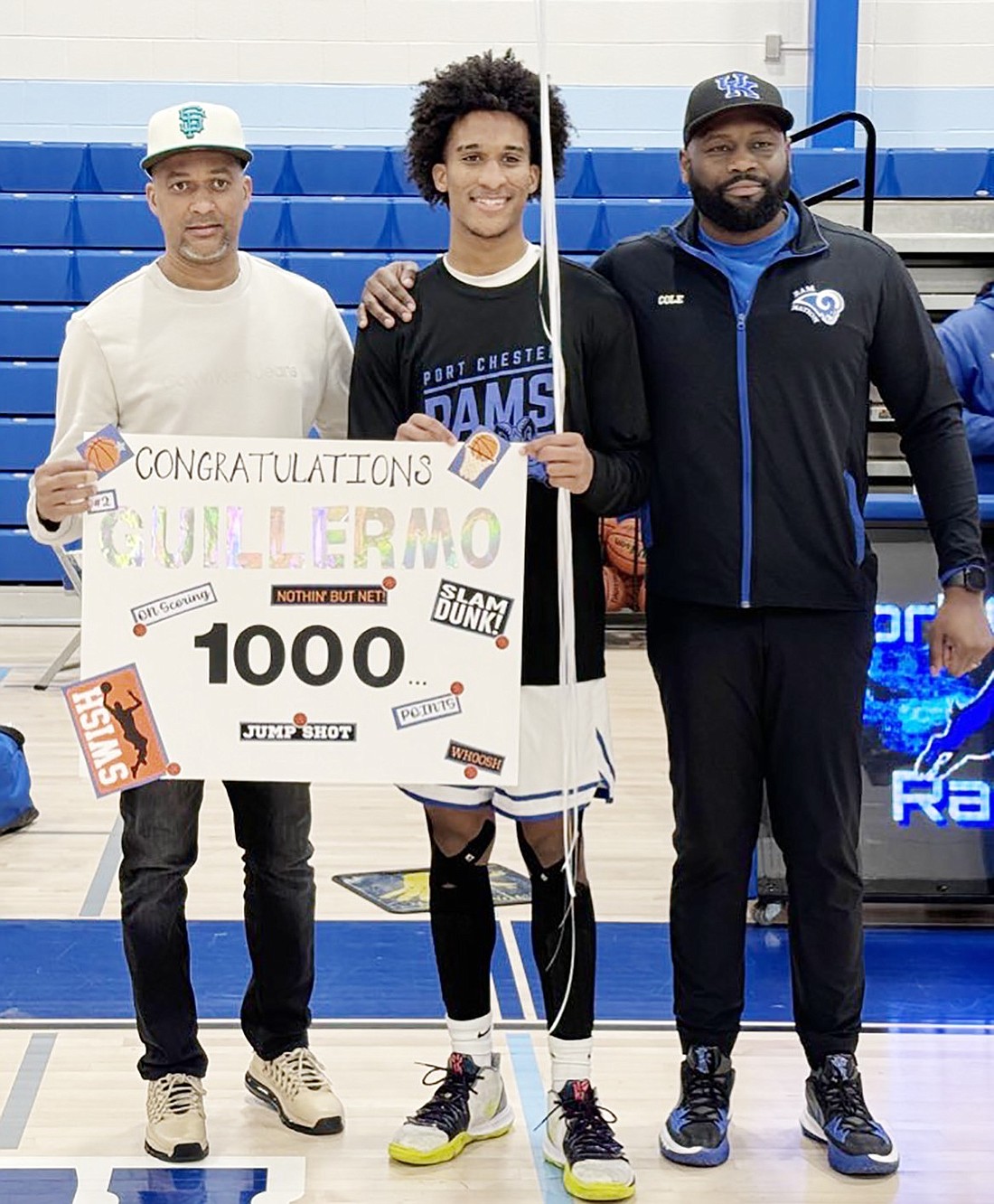 High-scoring Dominican Republic senior transfer Guillermo (Memo) Zabala is flanked by his father (left) and Port Chester head coach Greg Cole during a pre-game ceremony Tuesday, Feb. 6 honoring him as the first player in Ram basketball history to score 1,000 points during his two-year varsity career. The Rams lost Tuesday's home game to Horace Greeley with Zabala the top scorer with 18 points.