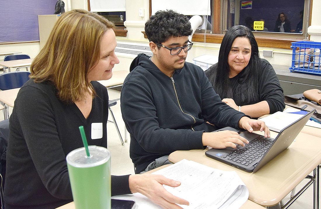 Latino U College Access volunteer Marie Guarnieri (left) walks Port Chester High School senior Sergio Leoni and his mother Isabella through the Free Application for Federal Student Aid (FAFSA) application. They’re participating in the Latino U-hosted FAFSA Bootcamp at Port Chester High School, an event designed to assist first-generation Latino students through the financial aid application on Thursday, Feb. 8.