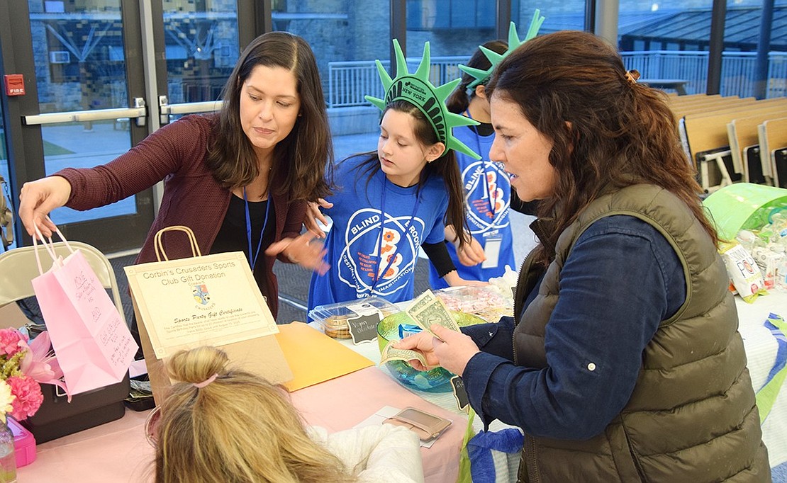 During intermission, Mariana Lomenso (left), a Destination Imagination parent, sells raffle tickets to Nicol Pirrazzi, a teacher at Ridge Street School.