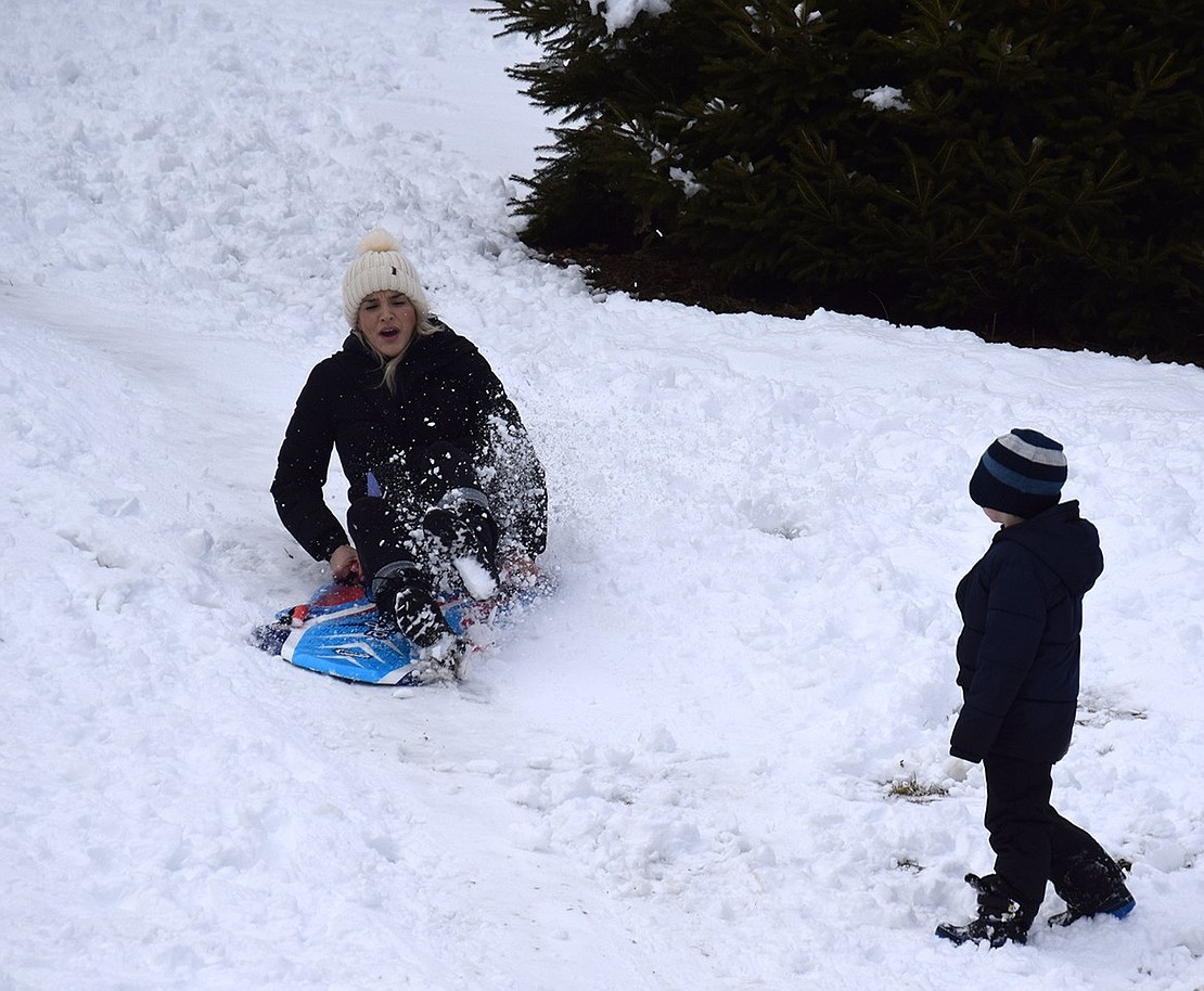 Christina Patafio tries her hand at sledding at Recreation Park while her son Gino watches. “I’m too old for this,” she muttered as she fell off the sled mid-hill.