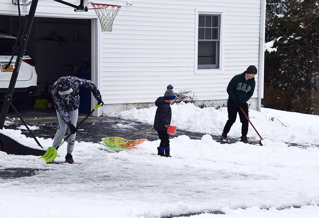 The Shis make shoveling a family affair as Jeremy Shi, 15, and his dad Lisong remove snow from their driveway on Old Oak Road while 5-year-old Jason keeps them company as he pulls his sled over the slippery surface.
