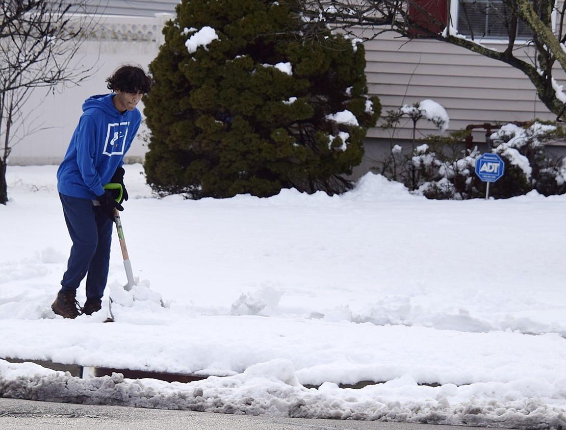 Shoveling sidewalks is a big job, especially when you live on a corner. Eighteen-year-old John Abraham takes on the task in front of his family’s house at the corner of Glen and Haseco avenues.