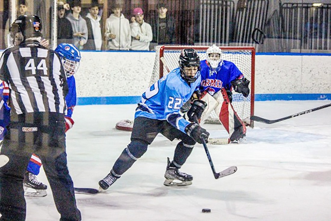 Rye Town-Harrison Titans player Julian Gahr (Harrison sophomore) successfully accepts an assist against Carmel on Tuesday, Feb. 6 at Playland Ice Casino in Rye.