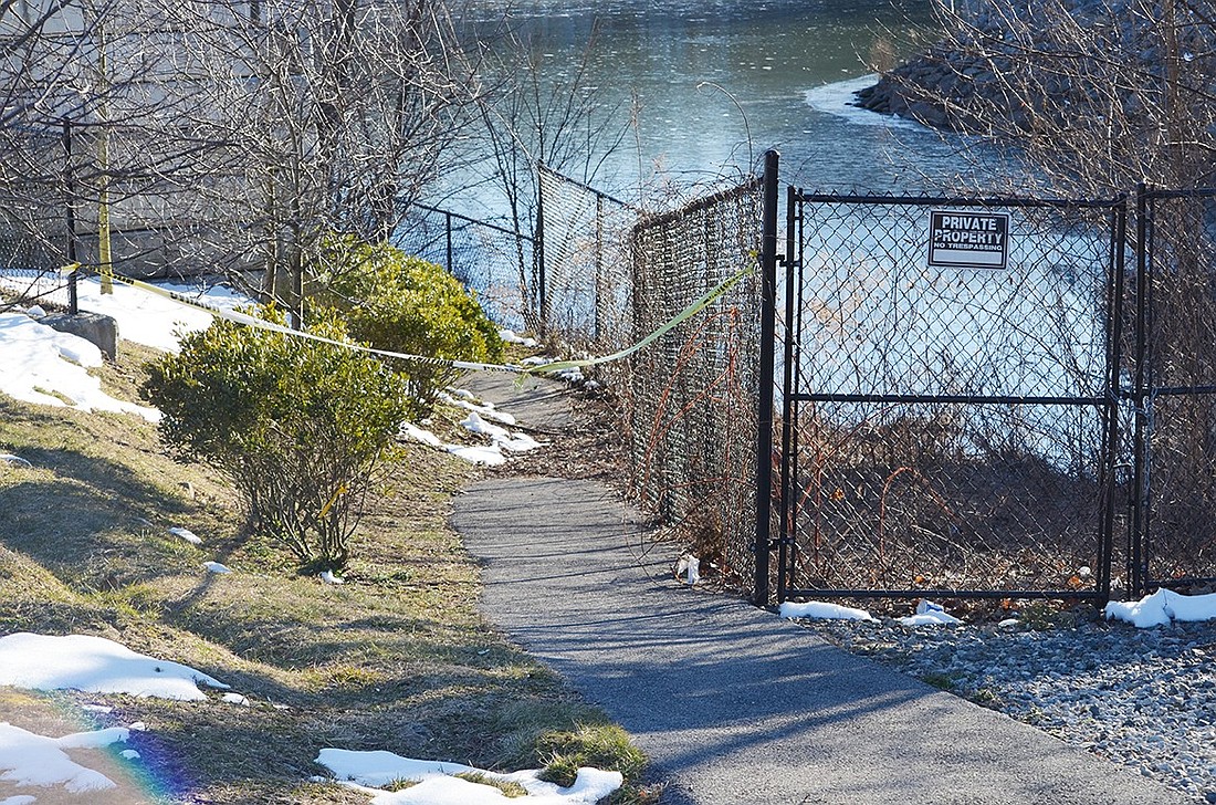 Yellow caution tape blocks the entrance to a waterfront park along “The Keyhole” that was largely built several years ago but never opened due to contamination that must be remediated. It is now the subject of litigation.