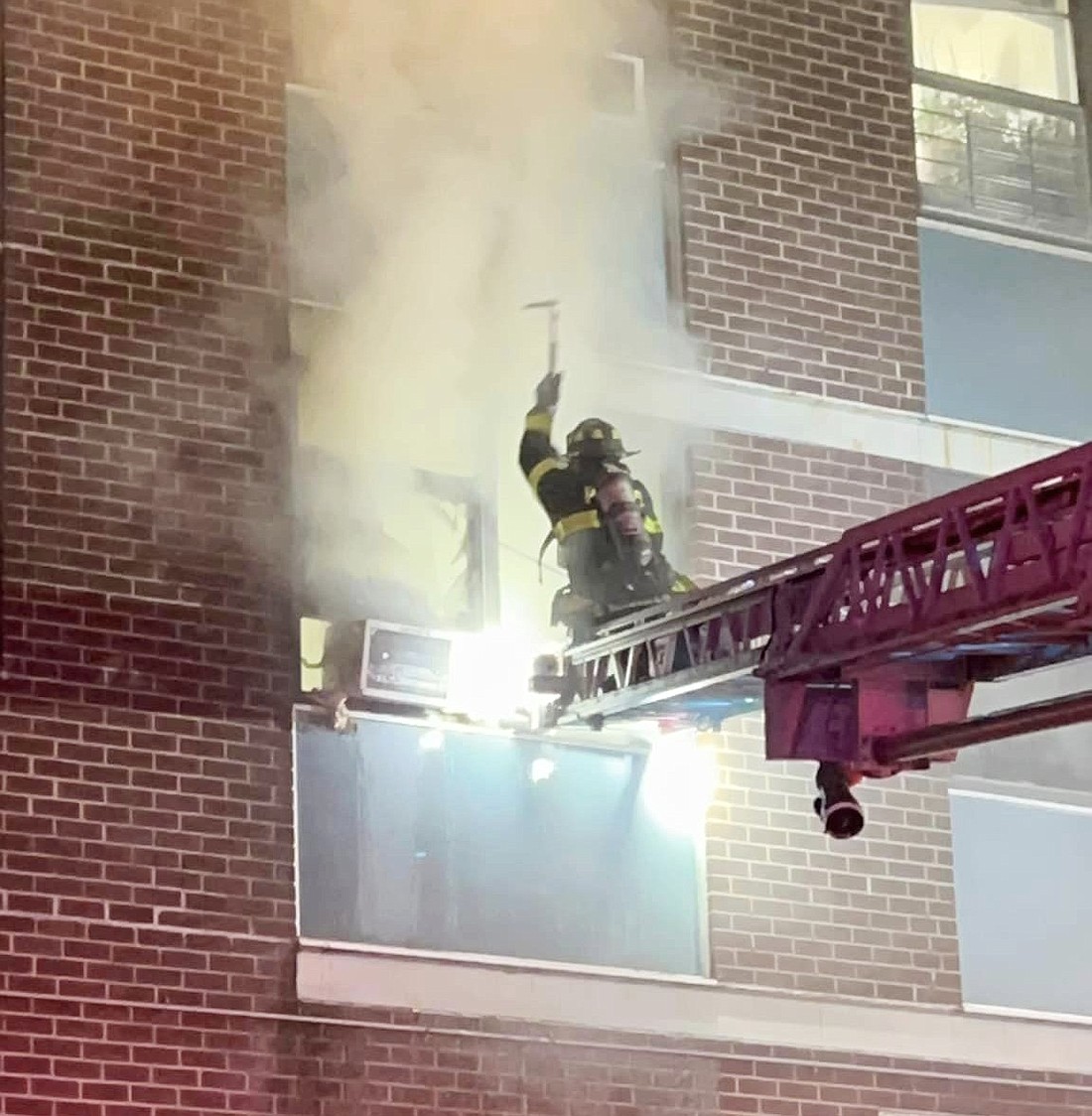 A member of the Port Chester Fire Department uses a tool to forcibly gain entry into a second-floor apartment at 167 Terrace Ave. while in the process of fighting a fire on Sunday, Feb. 25.